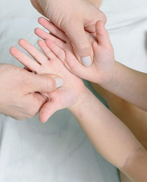 A mom pressing her thumbs into her childs palms, illustrating emotion regulation in post-LDS parenting.