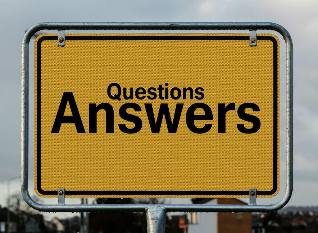 A metal yellow sign that reads 'Questions' in a small font with 'Answers' beneath in a larger font. Illustrating the question that lead to me leaving the LDS church.